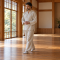 Hombre caminando despacio con las manos juntas en una sala de meditación.